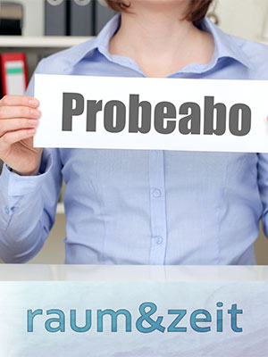 Das Bild zeigt eine Frau, die ein Schild mit Probeabo hochhält. Hier kommen Sie zu den Probeabos.